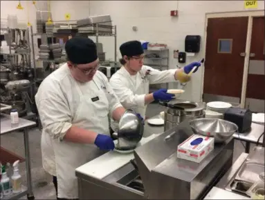  ?? CHAD FELTON — THE NEWS-HERALD ?? Noah Thompson, left, and Shane Prolenski prepare roasted tomato and basil bisque in the Auburn Room Restaurant kitchen on Dec. 13. The restaurant, run by the culinary arts program students, opened in early October and has been booked every Thursday. Now closed for the semester, the eatery will reopen in mid-February and offer a new menu.