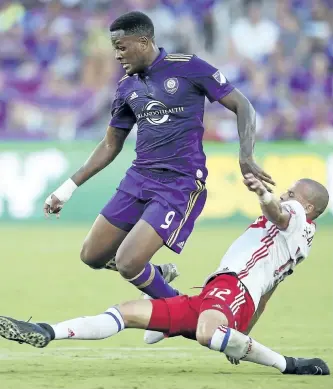  ?? STEPHEN M. DOWELL/AP FILES ?? Toronto FC’s Jason Hernandez tackles Orlando City’s Cyle Larin during an MLS match earlier this month. Larin trained for the first time with Canada on Monday after being added to the Canadian roster in advance of Thursday’s Gold Cup quarter-final...