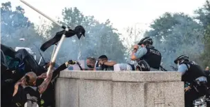  ?? SUN-TIMES FILE PHOTO ?? LEFT: Protesters surrounded the statue of Christophe­r Columbus in Grant Park on July 17, 2020. They tried to pull down the statue and battled with police, with some reportedly throwing frozen water bottles at officers. The statue was removed and could be returned.