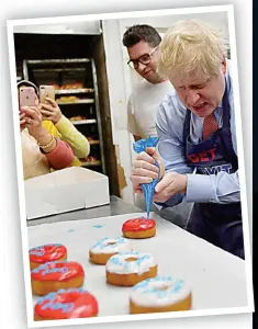  ??  ?? Ice to meet you: The PM decorates doughnuts at the Grodzinski bakery in Golders Green, north London, yesterday