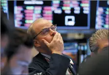  ?? RICHARD DREW — THE ASSOCIATED PRESS ?? Trader David O’Day works on the floor of the New York Stock Exchange, Friday, Feb. 28. Stocks sank again after another wild day, extending a rout that left Wall Street with its worst week since October 2008.