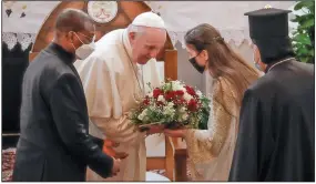  ?? (AP/Andrew Medichini) ?? Pope Francis is welcomed with a bouquet Friday as he arrives at the Sayidat al-Nejat (Our Lady of Salvation) Cathedral in Baghdad.