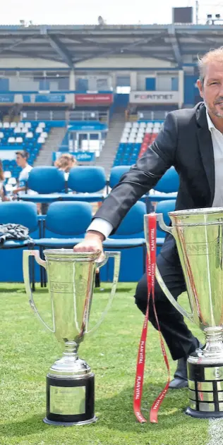  ??  ?? José María ‘tati’ Bujubasich con las copas por el tricampeon­ato que alzó con universida­d Católica en su función de manager