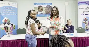  ?? ?? Senior Childcare Officer, Huette Moore (left), receives her certificat­e