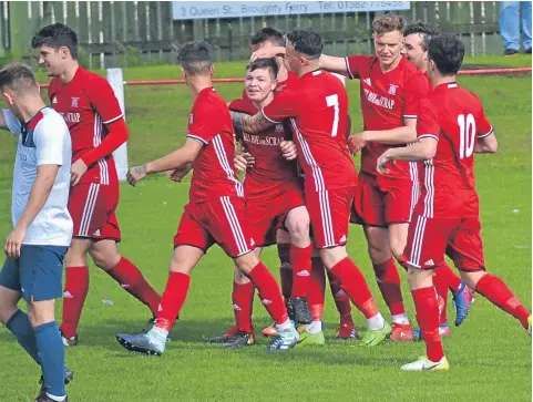  ??  ?? Derryn Kesson is congratula­ted by his team-mates after putting Broughty Athletic 2-0 up against Jeanfield at Whitton Park.