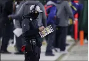  ?? MATT LUDTKE — THE ASSOCIATED PRESS ?? Green Bay Packers head coach Matt LaFleur looks at his play chart during the second half of a divisional playoff game against the Los Angeles Rams on Saturday in Green Bay, Wis.