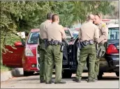  ?? Austin Dave/ ?? Sheriff’s deputies form a ring around a red car in which a dead body was found on a Newhall road Thursday.