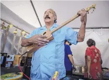  ?? ROBERTO E. ROSALES/JOURNAL ?? Cipriano Vigil shows off one of his cigar-box guitars.