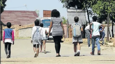  ?? /THULANI MBELE ?? Children walk past AB Xuma primary, the school where a school patroller and a forensic investigat­or allegedly molested students.