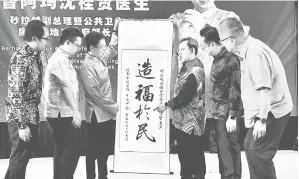  ?? ?? TANDA INGATAN: Dr Sim (tiga kanan) menerima menerima cenderamat­a daripada Kiing (tiga kiri) sambil disaksikan (dari kiri) Izkandar, Chieng, Tiang dan Ting pada Sambutan Tahun Baharu Cina MPS di Sibu, semalam.