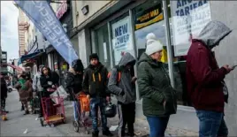  ?? Sarah Blesener/ The New York Times ?? A line forms outside a check- cashing business in New York in March. New York is more crowded than any large city in the country.