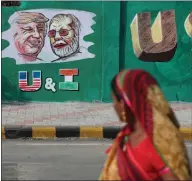  ??  ?? A woman looks at caricature­s of Donald Trump and PM Narendra Modi ahead of US President Trump’s visit to India