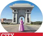  ??  ?? CITY Woman poses in front of massive arch