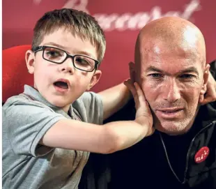  ?? — AFP ?? Good cause: Former French player and European Leukodystr­ophy Associatio­n (ELA) patron Zinedine Zidane posing with a child after the presentati­on of the “Zidane’s Crystal Foot” in Paris yesterday. French crystal glass maker Baccarat has created 100 units of Zidane’s Crystal Foot for the benefit of ELA.