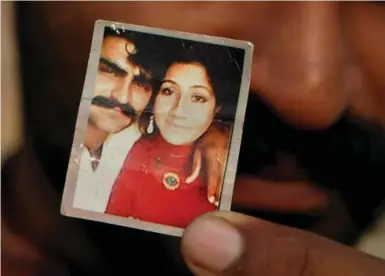  ?? K.M. CHAUDAR PHOTOS/THE ASSOCIATED PRESS ?? Mohammed Tofeeq shows a picture with his wife, Muqadas Tofeeq, who police say was killed by her mother, in Butrawala village on the outskirts of Gujranwala.