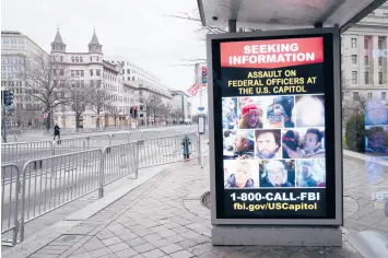  ?? SUSAN WALSH/AP ?? A bus stop along Pennsylvan­ia Avenue displays a poster from the FBI seeking informatio­n on the Capitol rioters last month in Washington, D.C.