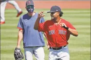  ?? Elise Amendola / Associated Press ?? Xander Bogaerts, right, runs past interim manager Ron Roenicke during training camp at Fenway Park on Tuesday.