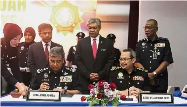  ??  ?? Historic day: Khalid (left) signing the corruption-free pledge at the Pulapol in Kuala Lumpur. Looking on are Dr Ahmad Zahid (centre) and Dzulkifli. — Bernama