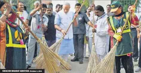  ?? PTI FILE ?? ■ PM Narendra Modi wields a broom with NDMC workers to launch the cleanlines­s campaign in New Delhi. SWACHH BHARAT ABHIYAN- October 2, 2014