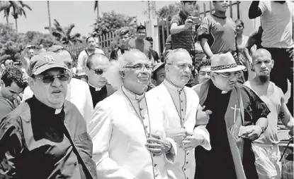  ?? AFP ?? El cardenal Leopoldo Brenes (c) junto al obispo Silvio Báez cuando se dirigían a apoyara un templo en Diriamba.