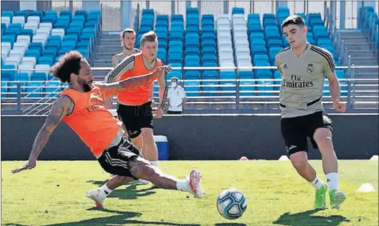  ??  ?? Presente y futuro en la misma foto. Marcelo intenta intercepta­r un paso del lateral juvenil Miguel Gutiérrez en una sesión de esta semana.