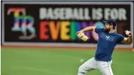  ?? The Associated Press ?? ■ Tampa Bay Rays relief pitcher Jalen Beeks warms up near a “Baseball is for Everyone” banner on the right field wall before a game against the Minnesota Twins June 7 in St. Petersburg, Fla.