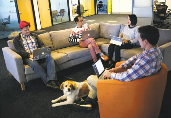  ?? Mason Trinca / Special to The Chronicle ?? Andrew Hammond (left), Taku Kawane, Ivy Yu and Andrey Burin use presumably secure computers in the common work area at AnchorFree in Menlo Park.