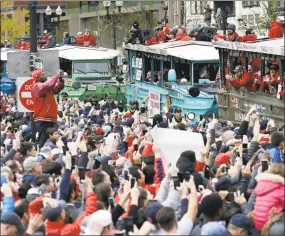  ?? Elise Amendola / Associated Press ?? Fans cheer the Boston Red Sox passing by in duckboats during a parade to celebrate the team’s World Series championsh­ip over the Los Angeles Dodgers on Wednesday in Boston.