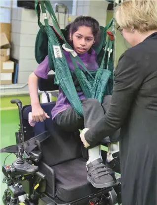  ?? JACQUES NADEAU LE DEVOIR ?? Lise, la préposée, utilise un lève-personne pour transférer Harini, 13 ans, dans un fauteuil roulant.
