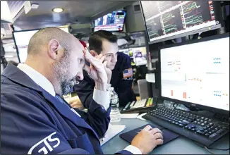  ??  ?? Specialist James Denaro, (left), works at his post on the floor of the New York Stock Exchange, Aug 5. US stocks nosedived in early trading on Wall Street Monday as China’s currency fell sharply and stoked fears that the trade
war between the world’s two largest economies would continue escalating. (AP)