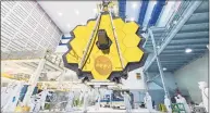  ?? Desiree Stover / NASA via Associated Press ?? Technician­s lift the mirror assembly of the James Webb Space Telescope inside a clean room in 2017 at NASA’s Goddard Space Flight Center in Greenbelt, Md.