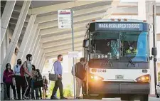  ?? Mark Mulligan / Staff photograph­er ?? Commuters at the Grand Parkway park and ride line up to board a Metropolit­an Transit Authority bus headed downtown.