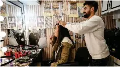  ?? ?? Turkish actress Canan Urekil (left), starring in the ‘Dengeler’ TV series, prepares her hair for a scene on the set.