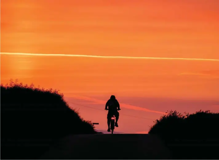  ?? ?? A man rides his bike on a small road in the outskirts of Frankfurt, Germany, before sunrise on Tuesday, May 30, 2023. Photo : AP/Michael Probst.