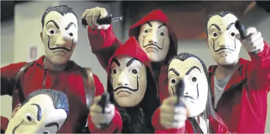  ?? NETFLIX ?? Personajes de la serie, ataviados con el caracterís­tico mono rojo y la máscara, en ‘La casa de papel’.