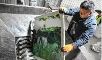  ?? — AFP ?? A worker places a wedding photo into a shredding machine at a warehouse in Langfang, in northern China’s Hebei province.