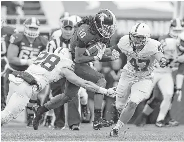  ?? Kirthmon F. Dozier / Detroit Free Press ?? Michigan State’s Felton Davis III, center, makes a run for it with after a reception as Penn State’s Troy Apke, left, and Brandon Smith close in during first-quarter action Saturday.