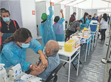  ?? ESTEBAN FELIX/AP ?? A health care worker inoculates a man with a dose of the Sinovac COVID-19 vaccine at a vaccinatio­n center set up at the Bicentenar­io Stadium in Santiago, Chile, on Feb. 3.