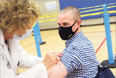  ?? Ned Gerard / Hearst Connecticu­t Media ?? Benjamin Powers, head of school at Southport School in Fairfield, receives a COVID-19 vaccinatio­n at the Bigelow Center clinic in Fairfield on Monday.