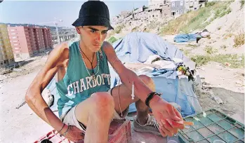  ?? GAEL CORNIER/THE ASSOCIATED PRESS ?? A homeless addict shoots up at the Casal Ventoso slum in Lisbon in 2000. The shantytown has since been razed, with new social housing units built for its residents who weren’t addicts.