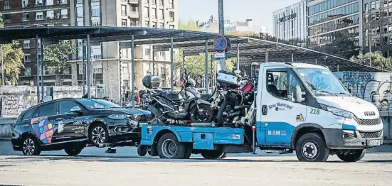  ?? Llibert Teixidó ?? La grúa municipal se lleva un coche con licencia VTC en las proximidad­es de la estación de Sants