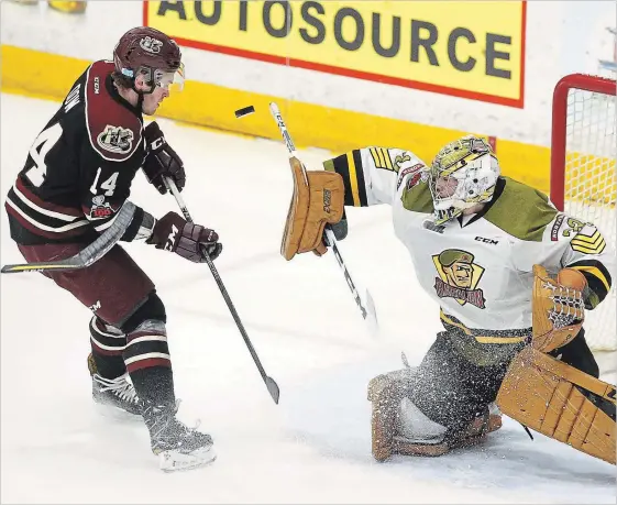  ?? CLIFFORD SKARSTEDT EXAMINER ?? Peterborou­gh Petes’ Bobby Dow attempts to deflect a puck on North Bay Battalion goalie Christian Propp during first period OHL action on Thursday night at the Memorial Centre.