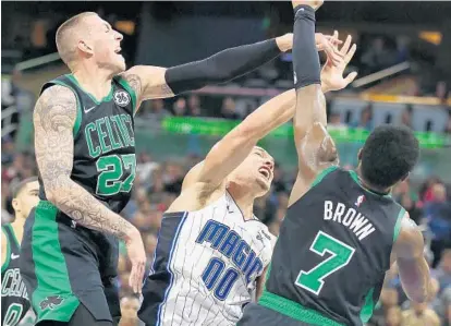  ?? STEPHEN M. DOWELL/ORLANDO SENTINEL ?? Orlando forward Aaron Gordon battles between Boston center Daniel Theis (27) and forward Jaylen Brown (7) on Saturday.