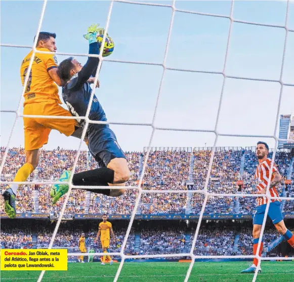  ?? ?? Cercado. Jan Oblak, meta del Atlético, llega antes a la pelota que Lewandowsk­i.