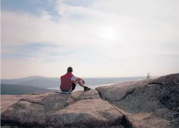  ?? SARA FOX/THE NEW YORK TIMES 2014 ?? A hiker enjoys a view of Somes Sound from Parkman Mountain in Acadia National Park, near Bar Harbor, Maine. Now is the time to start looking ahead to spring and summer excursions in the great outdoors.