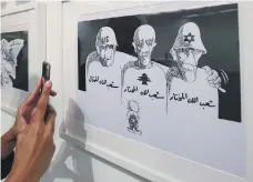  ?? AFP ?? Above, a caricature on display as part of an exhibition in Kuwait by celebrated cartoonist Naji Al Ali, left, who was shot in 1987