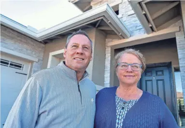  ?? JOEL ANGEL JUAREZ/THE REPUBLIC ?? Scott and Cindy Fisher stand in front of their newly purchased home in Goodyear on Jan. 18. The Fishers left Florida’s hurricanes behind and searched the Valley for a home with green space and mountain views.
