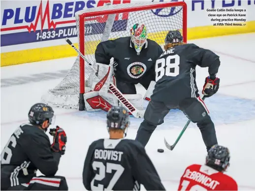  ?? AP ?? Goalie Collin Delia keeps a close eye on Patrick Kane during practice Monday at Fifth Third Arena.