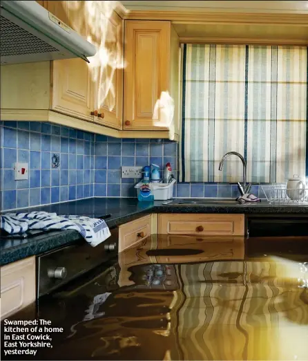  ??  ?? Swamped: The kitchen of a home in East Cowick, East Yorkshire, yesterday