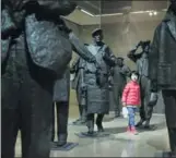  ?? JIANG DONG / CHINA DAILY ?? A young visitor walks among sculptures by Anthony Stones at the show BetweenChi­naandWest at the National Art Museum of China in Beijing.